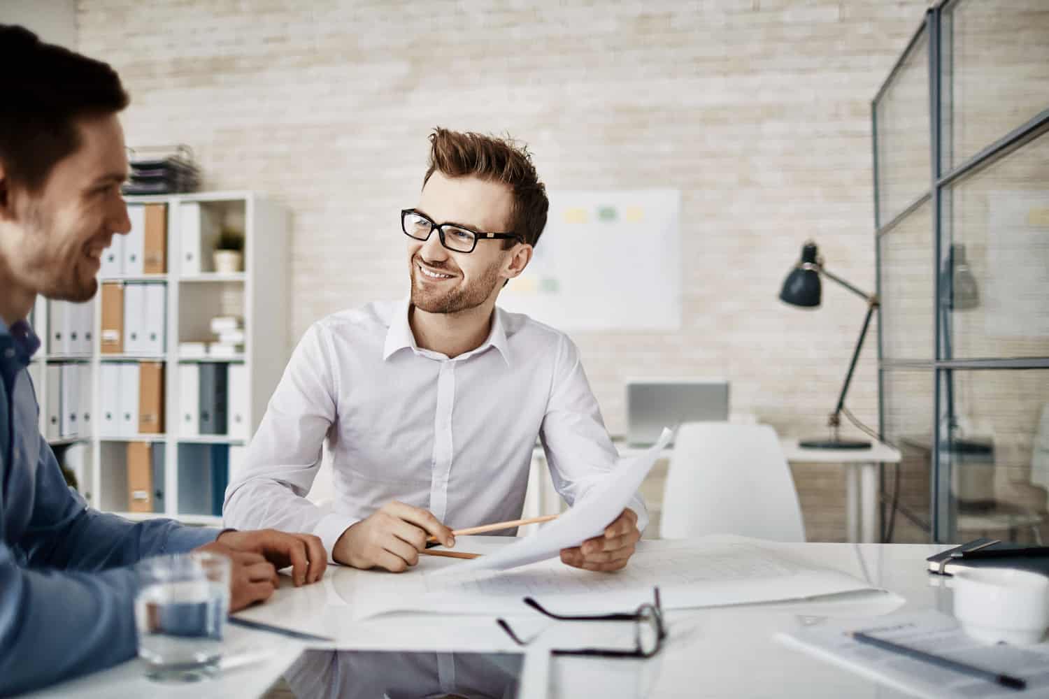 An IT consultant talking a client through options across a meeting-room desk
