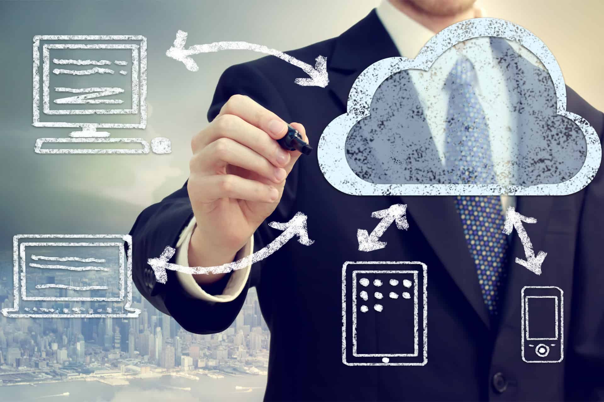 A consultant sketching cloud services linking desktops, tablets and phones